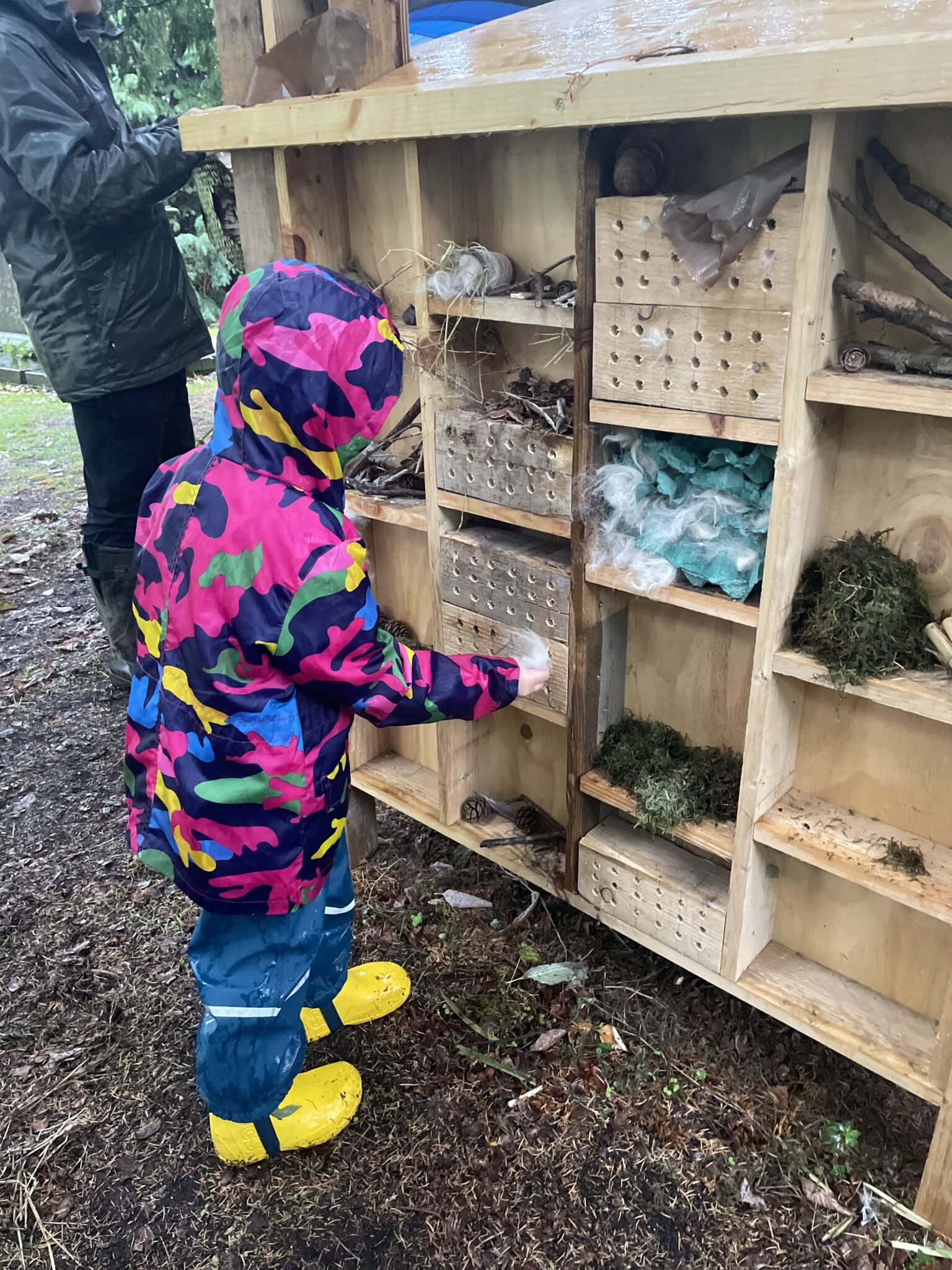 A child helping complete the Minibeast Monastery at Wild Worship in September 2025.